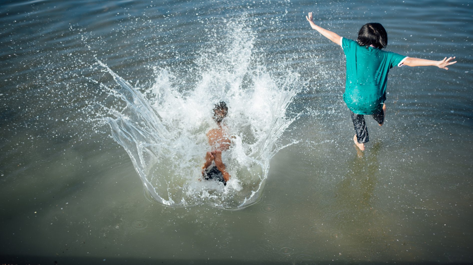 Active boys jumping from logs into water 1